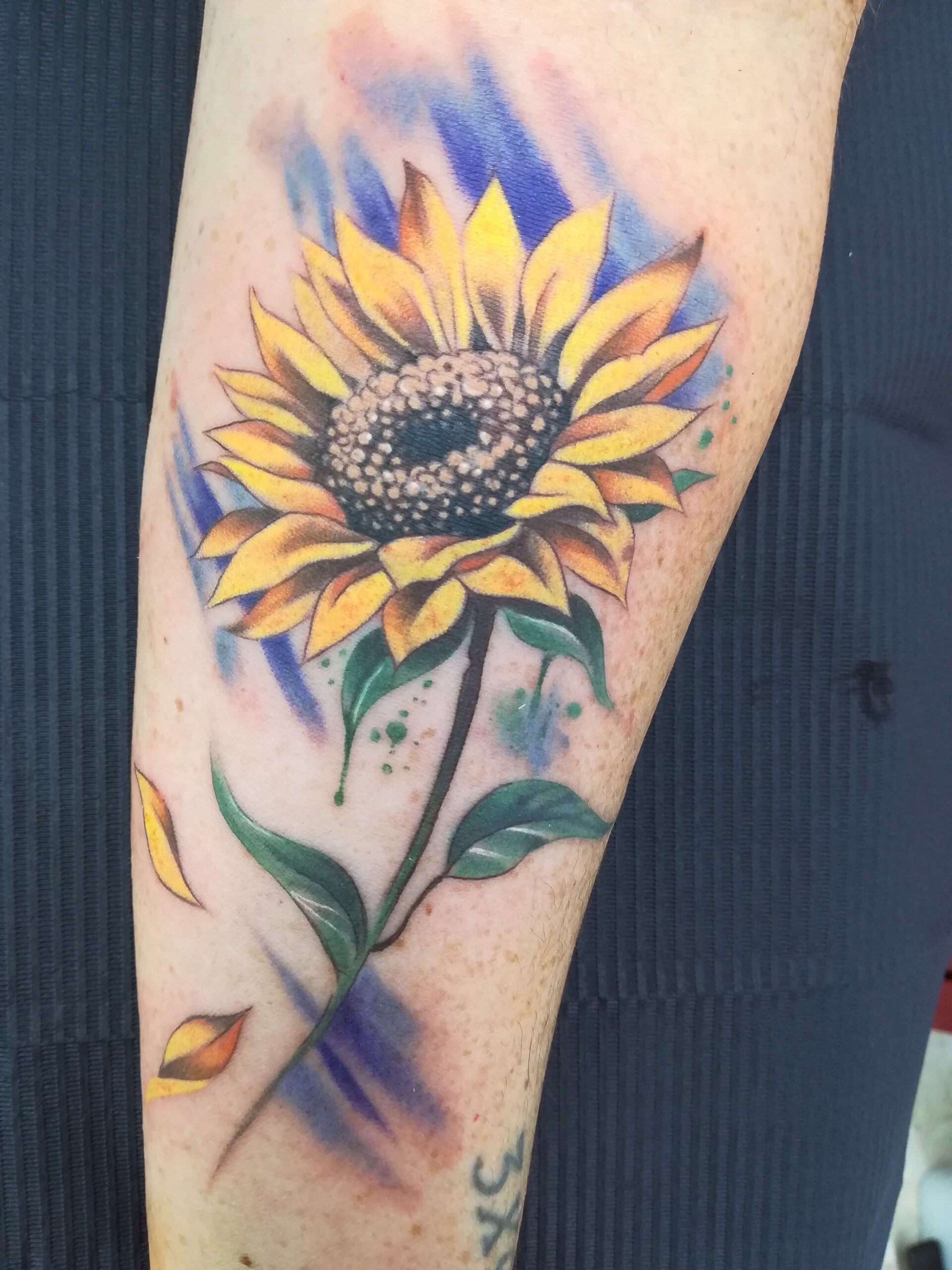 Tatuaje a color de Lily Bone. Girasol.